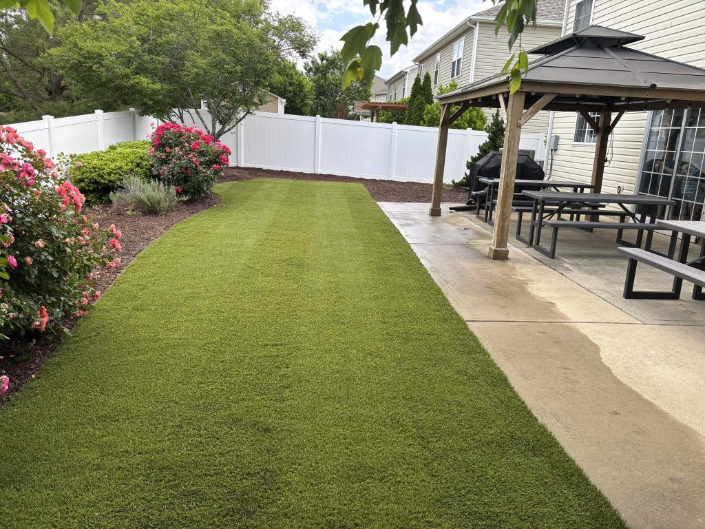 artificial lawns with beautiful flower bed with pink shrubs