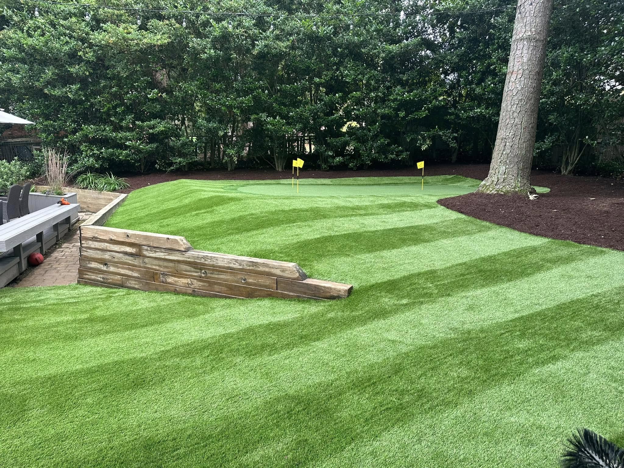 professional artificial turf installed in backyard with putting green