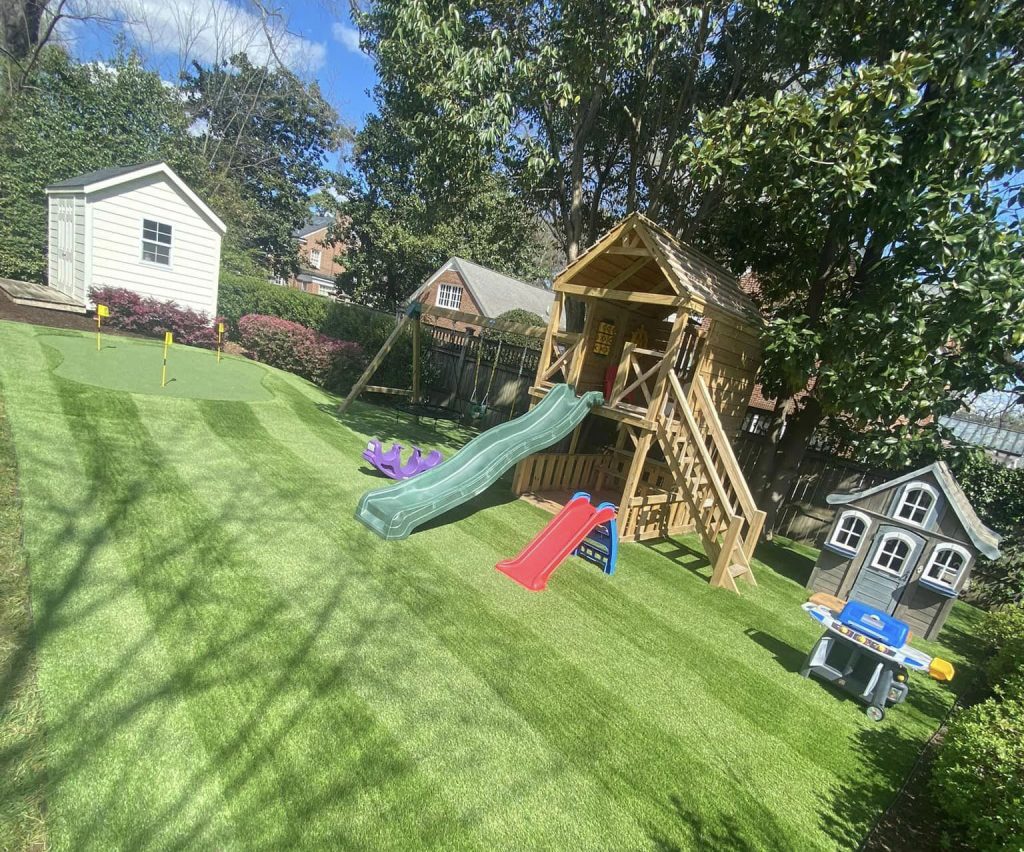 play area turf in backyard with swings and slide