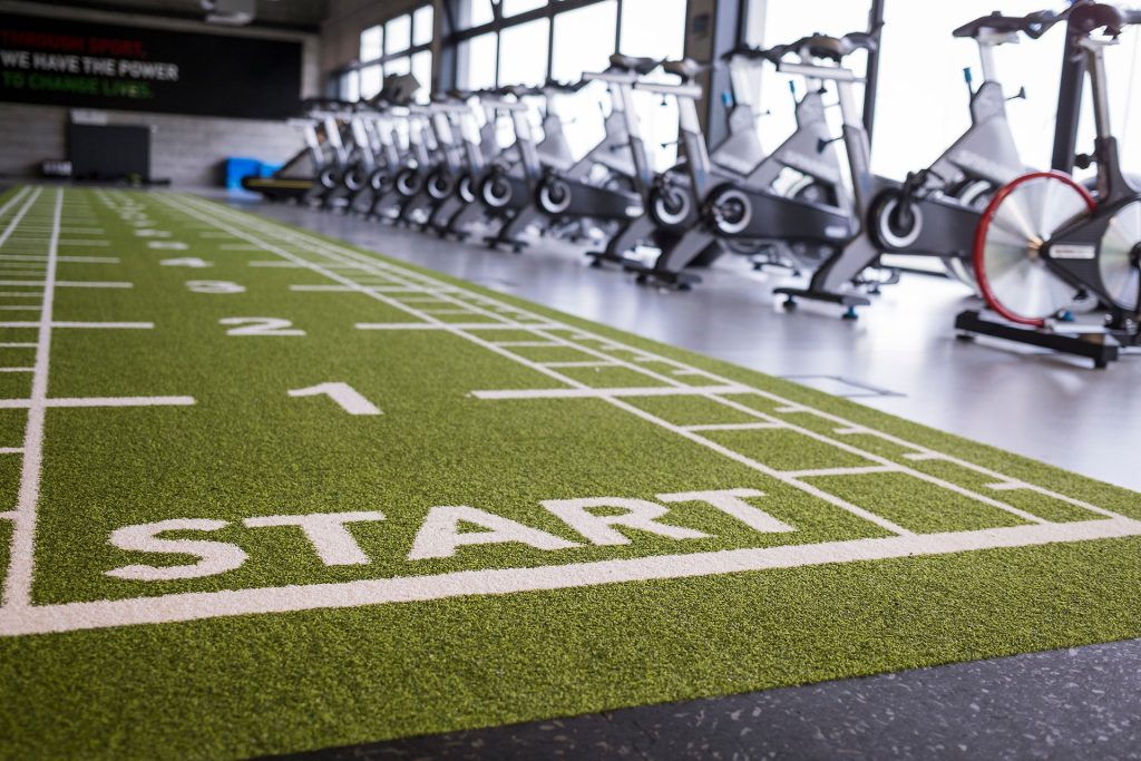 Artificial grass in the sport hall with the gym in background